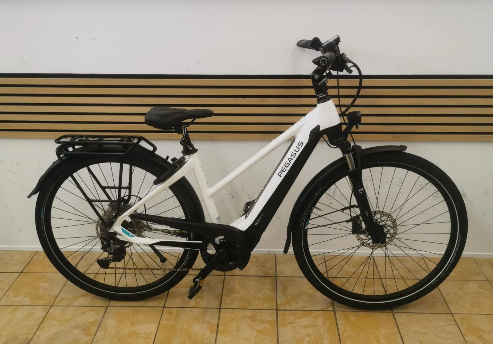 Pegasus E-Trekkingrad in Weiß mit Trapezrahmen, Mittelmotor, Gepäckträger und Schutzblechen