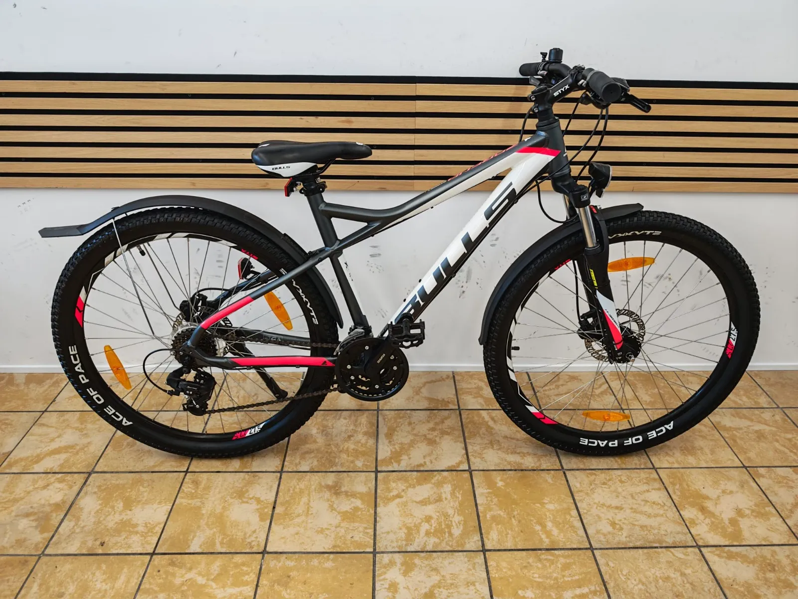 Bulls Mountainbike in Grau-Weiß mit pinken Akzenten, Schutzblechen und Scheibenbremsen
